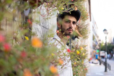 Etrafı renkli çiçeklerle çevrili, Madrid 'de beyaz mumya olan genç bir çocuk.