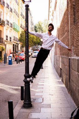 Madrid sokaklarında sokak lambası kullanan bereli genç bir çocuk.