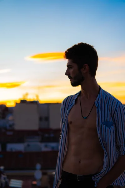 Chueca 'da çatıda tişörtü açık bir çocuk profili var.