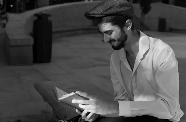 Madrid 'de bir parkta kırmızı kitap okuyan genç bir çocuk.