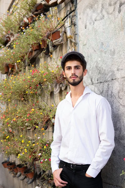 Etrafı renkli çiçeklerle çevrili, Madrid 'de beyaz mumya olan genç bir çocuk.