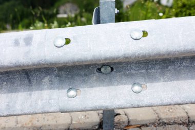 Galvanize ya da metal yol bariyerleri, yakın plan, metal cıvatalarla tutturulmuş. Yol güvenliği, koruyucu yapılar.