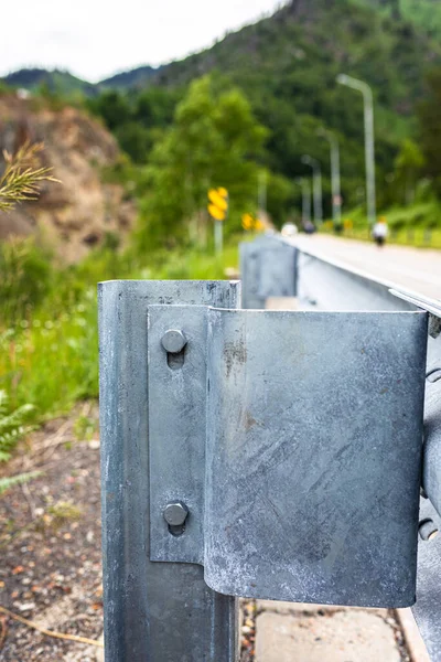 Galvanized or metal road barriers, close-up, fastening with metal bolts. Road safety, protective structures.