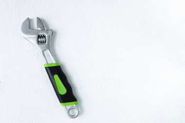 Bir anahtar, yakın plan, eskimiş beyaz arka plan. Düz çizgi. Ev onarımı için aletler. İnşaat alanında çalışıyorum..