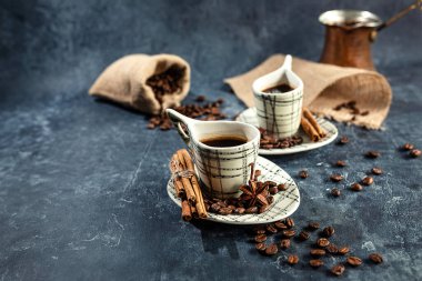 Açık fincanlı Arap kahvesi kompozisyonu, alışılmadık şekilli, koyu grafit arkaplanlı. Evde kahve yapma konsepti. seçici odak.