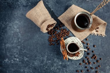 Açık fincanlı Arap kahvesi kompozisyonu, alışılmadık şekilli, koyu grafit arkaplanlı. Evde kahve yapma konsepti. seçici odak.