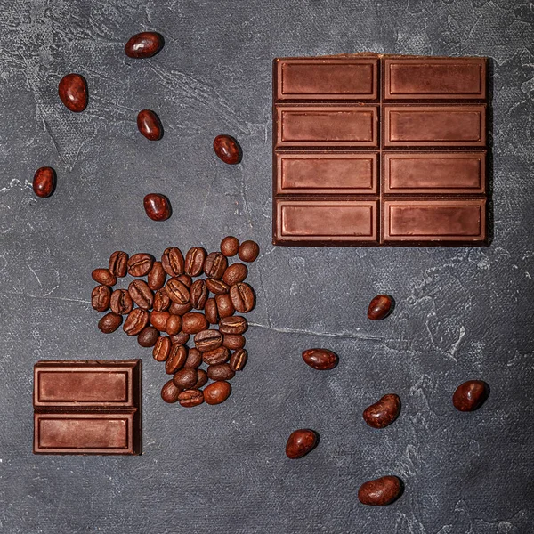 coffee beans and chocolate on a dark graphite background. selective focus.