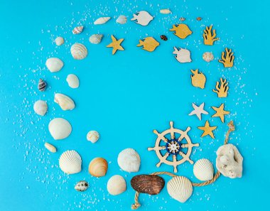 Deniz kabukları ve mavi arka planda ahşap figürlerle birlikte yaz kompozisyonu. Denizde yaz tatili kavramı. düz alan, kopyala boşluk.