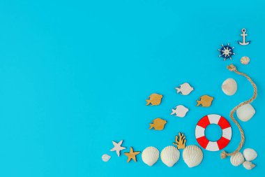 Deniz kabukları ve mavi arka planda ahşap figürlerle birlikte yaz kompozisyonu. Denizde yaz tatili kavramı. düz alan, kopyala boşluk.