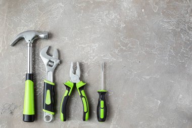 Çeşitli inşaat aletleri. Ev onarımı için aletler. İnşaat alanında çalışıyorum. Gri, pürüzlü beton arka planda. Düz yatıyordu.