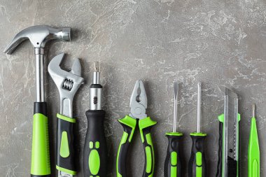 Çeşitli inşaat aletleri. Ev onarımı için aletler. İnşaat alanında çalışıyorum. Gri, pürüzlü beton arka planda. Düz yatıyordu.