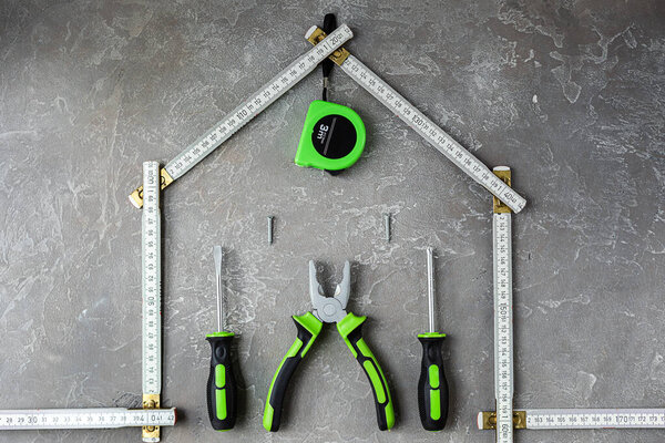 A set of various construction tools. Tools for home repair. Work on a construction site. On a gray, rough concrete background. Flat lay.