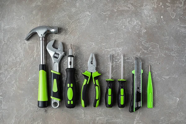 Çeşitli inşaat aletleri. Ev onarımı için aletler. İnşaat alanında çalışıyorum. Gri, pürüzlü beton arka planda. Düz yatıyordu.