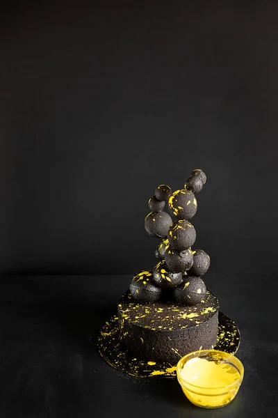 Чорний Жорстокий Торт Шоколадними Кульками Яскраво Жовтими Бризками Чорному Тлі — стокове фото