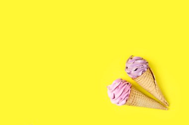 Waffle külahında ev yapımı böğürtlen şekerlemeleri, parlak sarı bir arka planda. Doğal malzemelerden yapılan sağlıklı tatlılar kavramı..