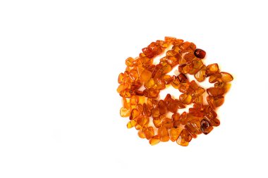 Beyaz arka planda izole edilmiş kahverengi kehribar parçalarından yapılmış bir kolye. Yukarıdan manzara. Boşluğu kopyala