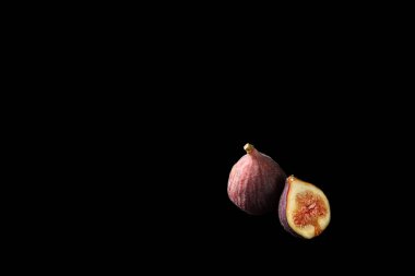 Siyah arka planda sulu olgun incirler.