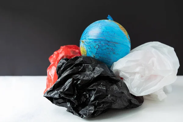 The globe is surrounded by plastic garbage. Concept of global environmental pollution and saving the planet.