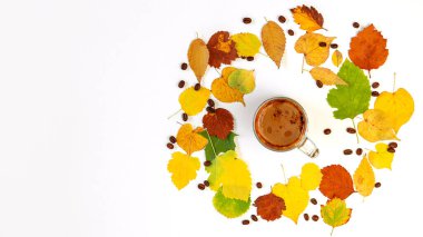 Sonbahar düz kompozisyon kahve fincanı parlak renkli kuru yapraklar ve beyaz arka planda duran kahve çekirdekleri ile birlikte. Yaratıcı sonbahar, Şükran Günü, Cadılar Bayramı konsepti. Üst görünüm, alanı kopyala