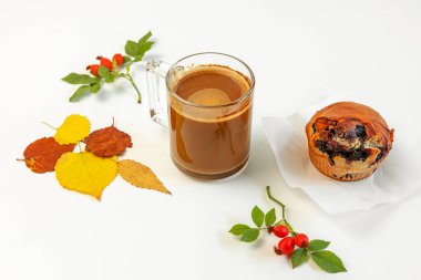 Sonbahar kompozisyonu kahve fincanı ve parlak renkli kuru yapraklardan oluşan arka planda beyaz arka planda duran meyveli kek. Yaratıcı düşüş, Şükran Günü, Cadılar Bayramı konsepti. Üst görünüm, alanı kopyala
