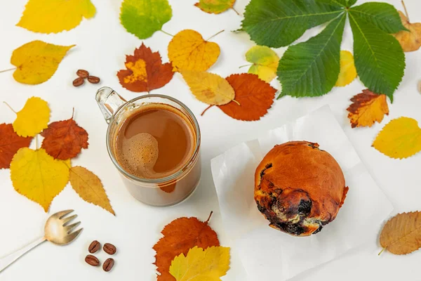 Autumn composition coffee Cup and berry cake on a background of brightly colored dry leaves lying on a white background. Creative fall, thanksgiving, Halloween concept. Top view, copy space