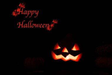 Karanlık bir arka planda yanan mumlarla parlayan balkabağı. Mutlu Cadılar Bayramı. 