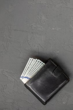 Gri beton arka planda dolarları olan siyah adam cüzdanı..