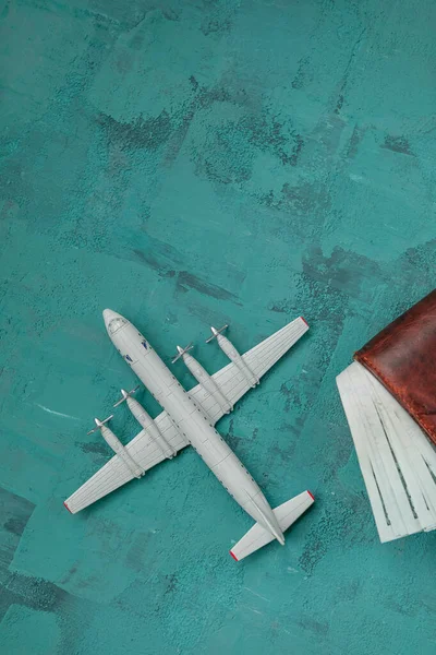 a toy plane on a green concrete background, a man\'s wallet with dollar bills, the concept of closing borders around the world due to coronavirus, financial losses of airlines and tour operators.