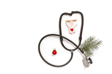 Üzerinde steteskop ve beyaz arka planda ladin dalı olan bir tıbbi Noel kartı. Yeni yılın ilacı. Uzayı kopyala Düz yatıyordu. 