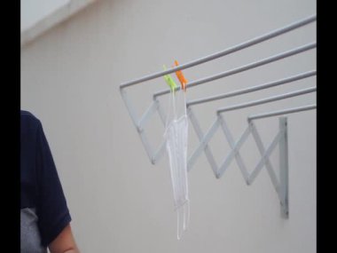 Ibi, İspanya. 24 Eylül 2020. Yeniden kullanılabilir yüz maskeleri asan kişi.