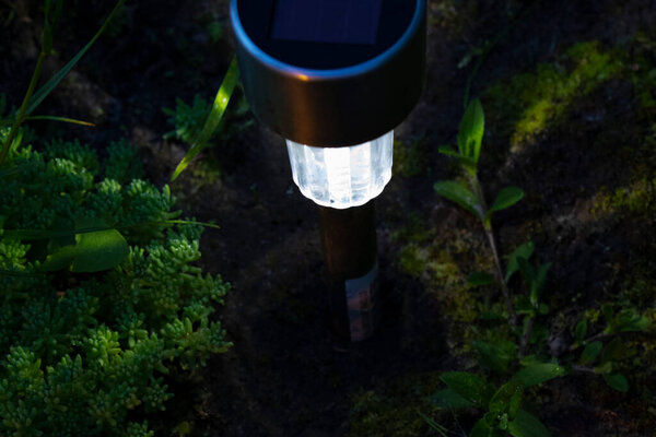 фонарь с солнечной батареей в природе ночью
