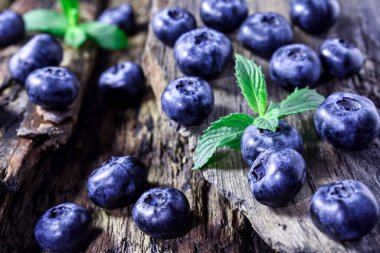 Taze, sulu yaban mersini, ahşap arka planda nane yaprakları. Böğürtlen Sağlıklı çerez.