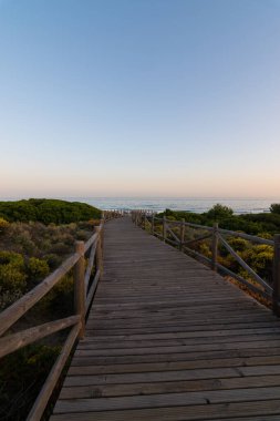 Gün batımı plajına giden ahşap yol.