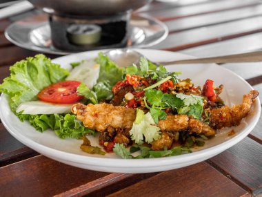 Kızarmış peygamber devesi karidesi beyaz tabakta servis edilir.