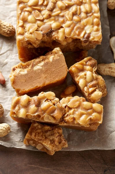 Old Fashioned Buttermilk Penuche Fudge candy with peanuts on a wooden table. Close up top view, selective focus