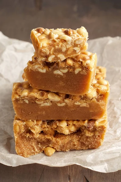 Old Fashioned Buttermilk Penuche Fudge candy with peanuts on a wooden table. Close up view