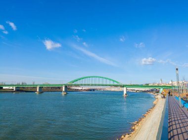 Sava nehri tarafından bölünmüş Belgrad kıyılarını birbirine bağlayan eski bir demiryolu köprüsü. Parlak güneşli bir gün Ufukta bulutlar.