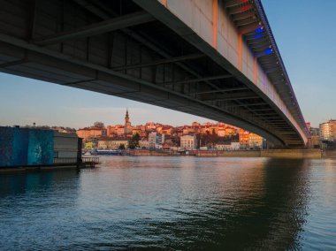 Alacakaranlıkta Branko köprüsü altında Belgrad şehri manzarası.