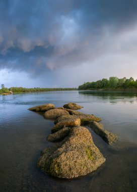 Gün boyunca Sava Nehri 'ndeki kayaların dramatik bulutlara karşı manzarası. Fırtınalı havalarda zıt manzaralar.