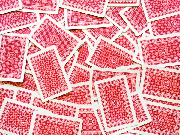 Kırmızı sırtlı dağınık iskambil kağıtlarının üstünde..