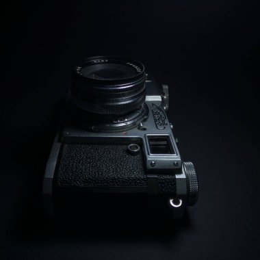 Antik Rus ya da Sovyet profesyonel DSR kamerası. İçinde SSCB 'den filmler var. Karanlıkta siyah arka plana karşı retro fotoğraf ekipmanları var..