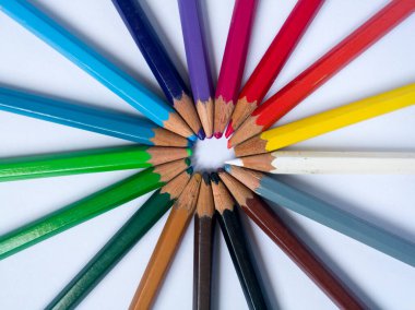 Eski kullanılmış ahşap boya kalemleri beyaz arka planda izole edilmiş üstlerle daire şeklinde dizilmiş, okul ekipmanları..