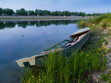 Bosanski Brod 'daki mavi saat boyunca Sava Nehri kıyısında çimlerde mahsur kalmış eski bir tekne..