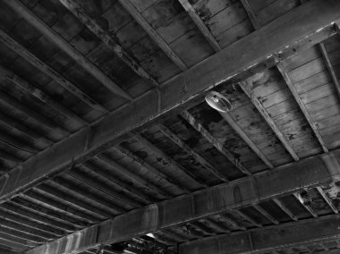 Kirli tavan, aydınlatma üniteleri, ampullü spot ışıkları, terkedilmiş eski bir sanayi salonunda..