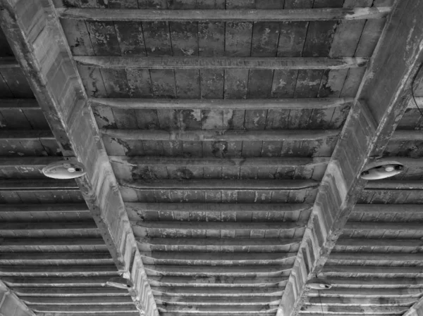 Dirty ceiling with lighting units, spotlights with light bulbs, in an old abandoned industrial hall.
