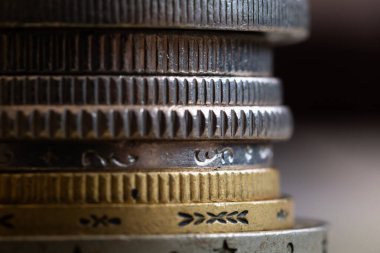 Çeşitli madeni paraların kenarları üst üste istiflenmiş, sazlanmış ve dekore edilmiş, çizikler ve aşınma hasarıyla işlenmemiş metal paralar.