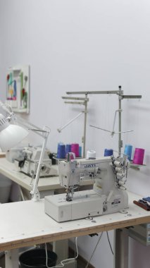 Krasnoyarsk. - Rusya. 05 Mart 2020. Profesyonel dikiş makinesinde, arka planda kilit ve dikiş aletleri olan renkli makaralar. Covid sırasında duralım, karantina. Dikiş dükkanı.