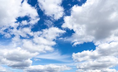 Mavi gökyüzünde bir sürü beyaz ve gri bulut var. Kabarık bulutlu arkaplan