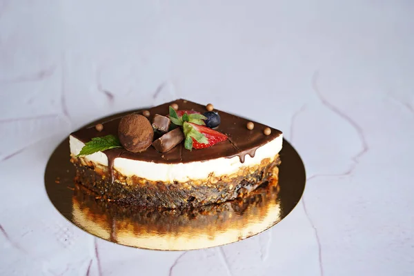 チョコレートケーキの4分の1チョコレート お菓子 新鮮なベリーで飾られた金の背景に白い背景のスニッカー — ストック写真