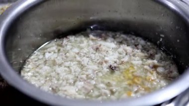 Çelik bir tencerede kıyılmış tavuk kachumber ve yağ..